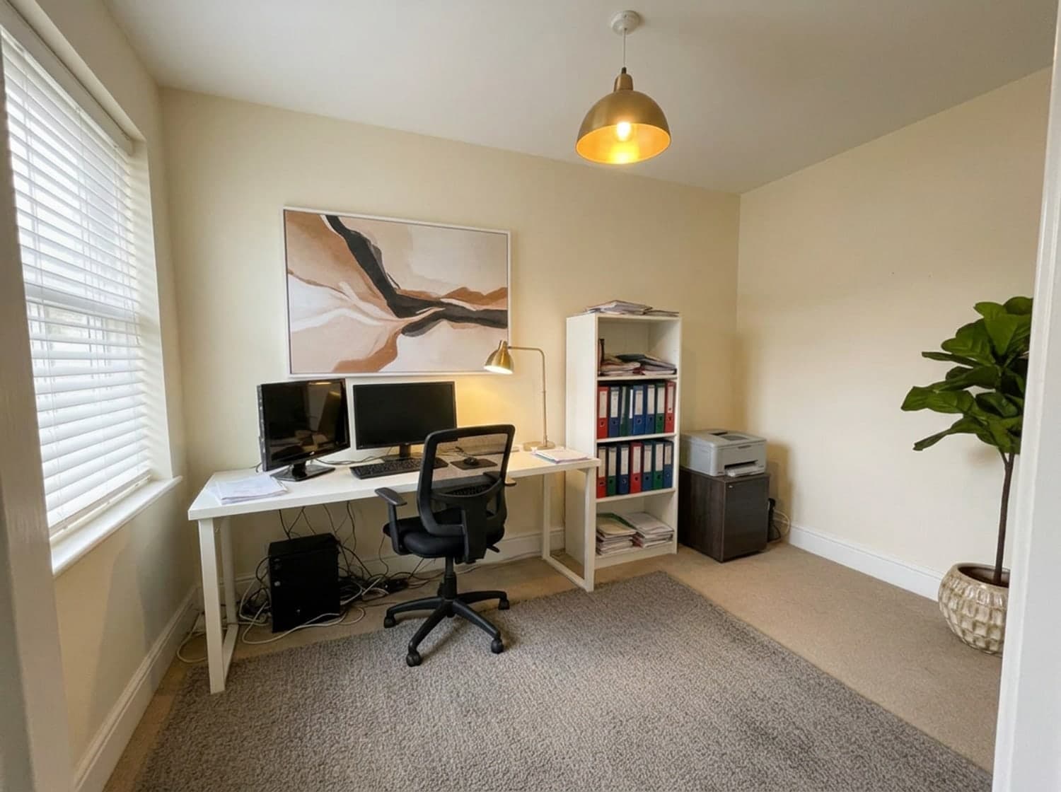 A home office after a RoomCalm Light refresh — The desk, chair, both monitors, the printer and the ring binders, same shelf, same order.